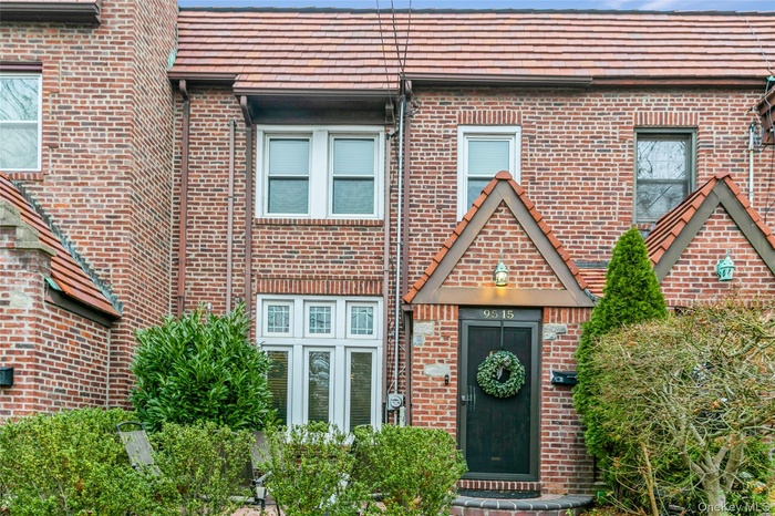 Doorway to property with brick siding and roof with shingles