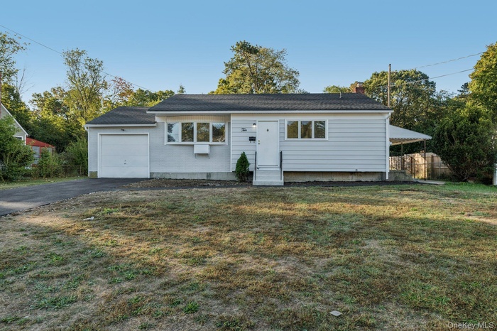 Ranch-style house with asphalt driveway, a chimney, and a garage