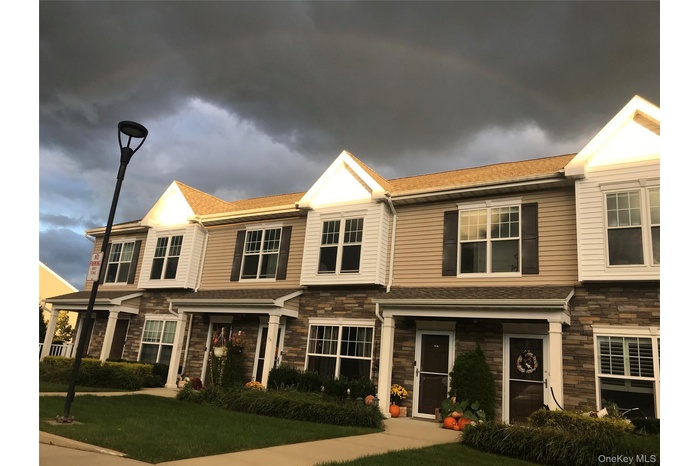 Craftsman-style home featuring stone siding, a front lawn, and a shingled roof