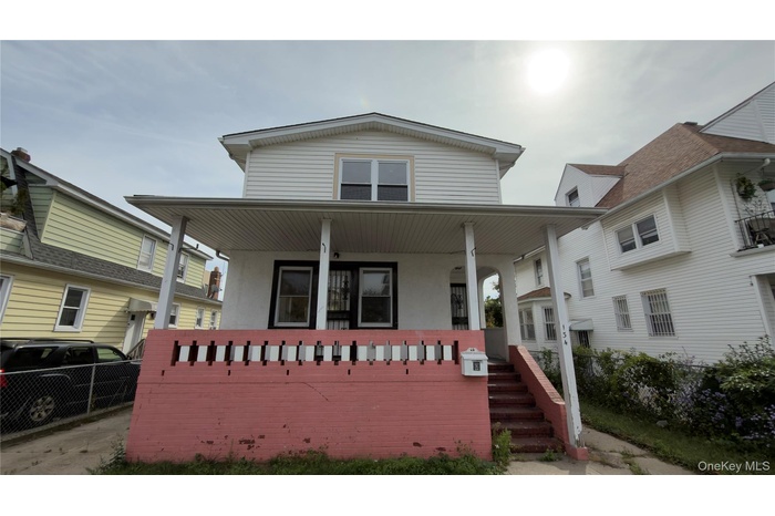 View of front of home featuring covered porch and stucco siding