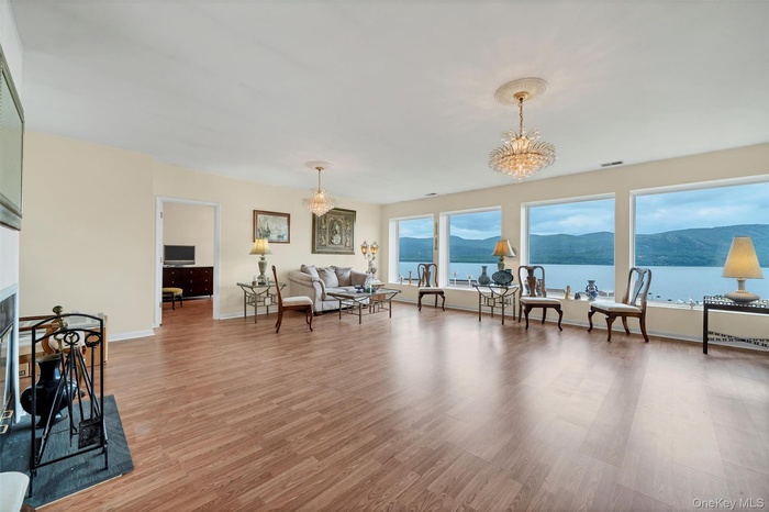 Living room with a chandelier, light wood-style floors, and a fireplace