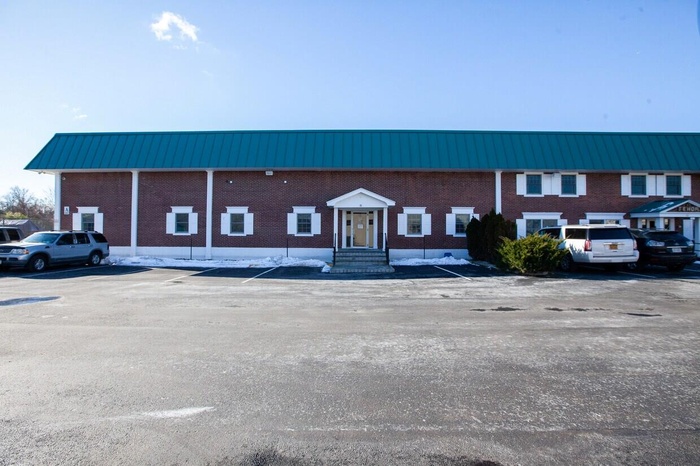 View of building exterior featuring uncovered parking