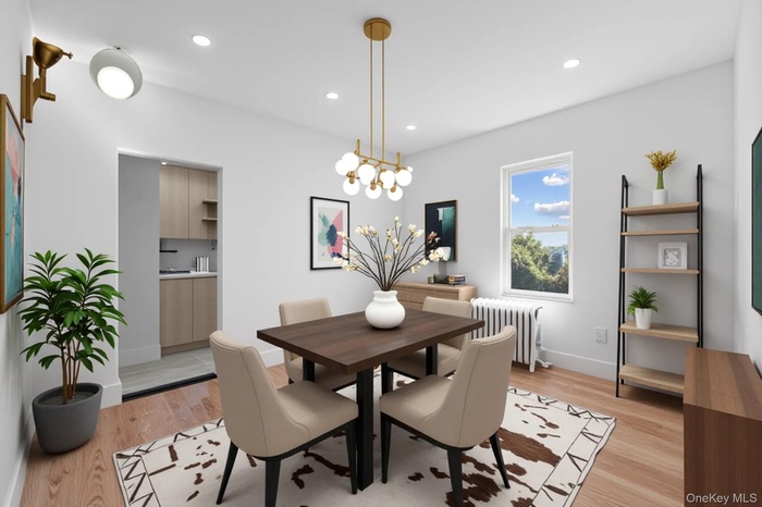 Dining room with radiator heating unit, light wood-style flooring, a chandelier, and recessed lighting