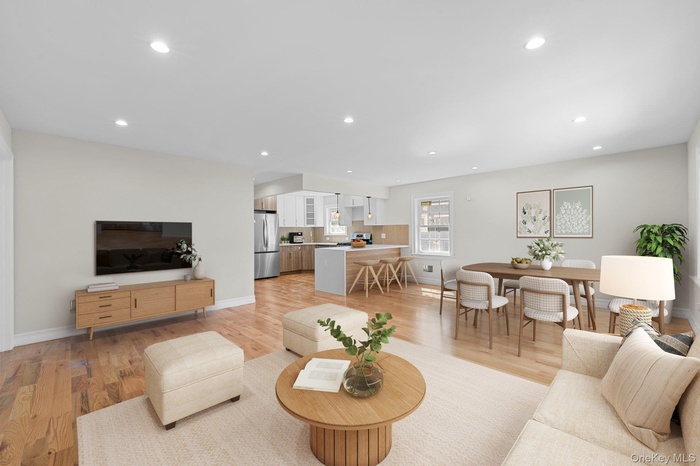 Living room with light wood-style flooring and recessed lighting