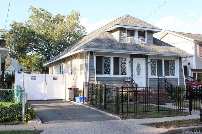 Bungalow with a fenced front yard, roof with shingles, and a gate
