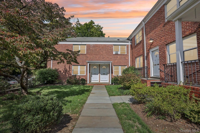View of front of property with brick siding and a front yard