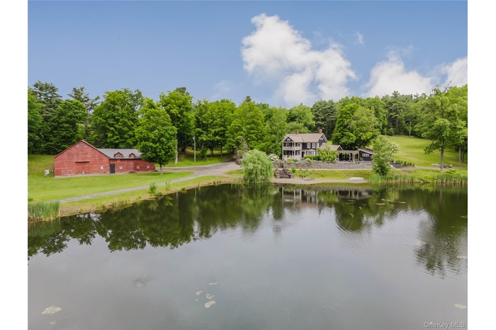 Water view with a barn and a heavily wooded area
