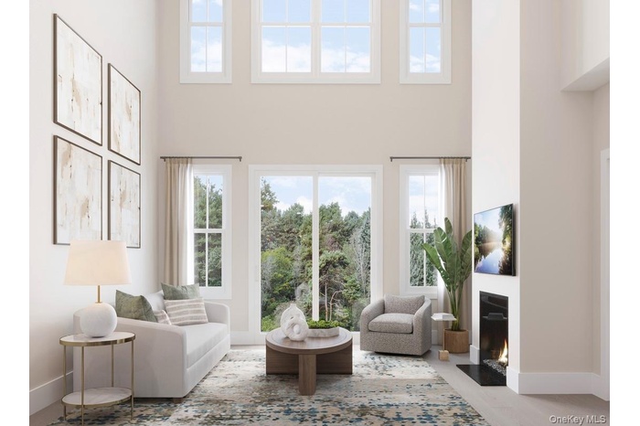 Living area with plenty of natural light, a high ceiling, and a gas fireplace.