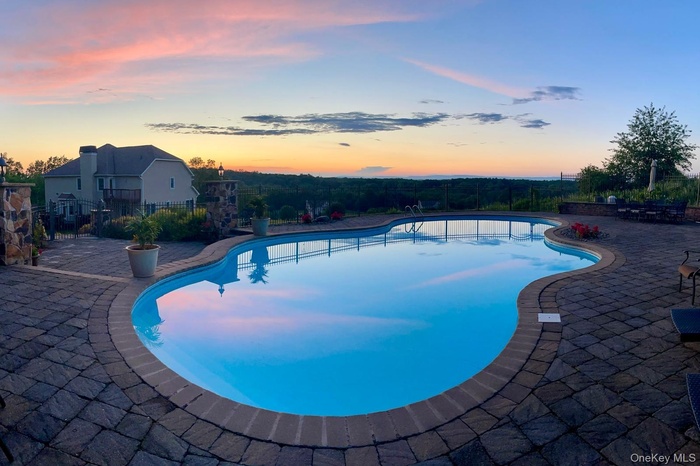 Twilight view of pool and sunset.