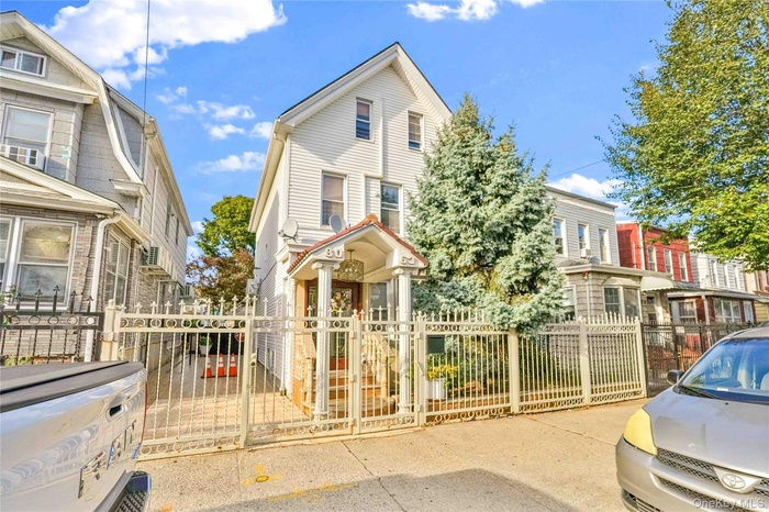 View of front of home with a gate, a fenced front yard, and a residential view