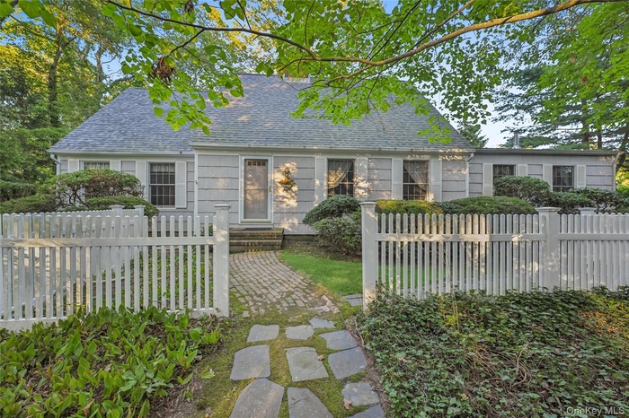 Front view of property with a fenced front yard and a shingled roof