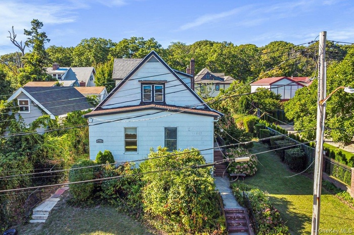 Back of property featuring view of scattered trees