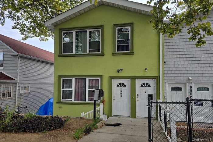 View of front of property featuring stucco siding and a gate