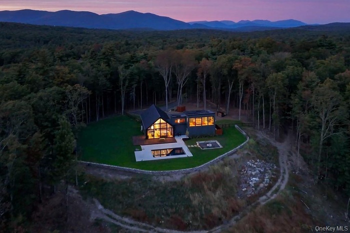 Aerial view of property and surrounding area featuring a heavily wooded area