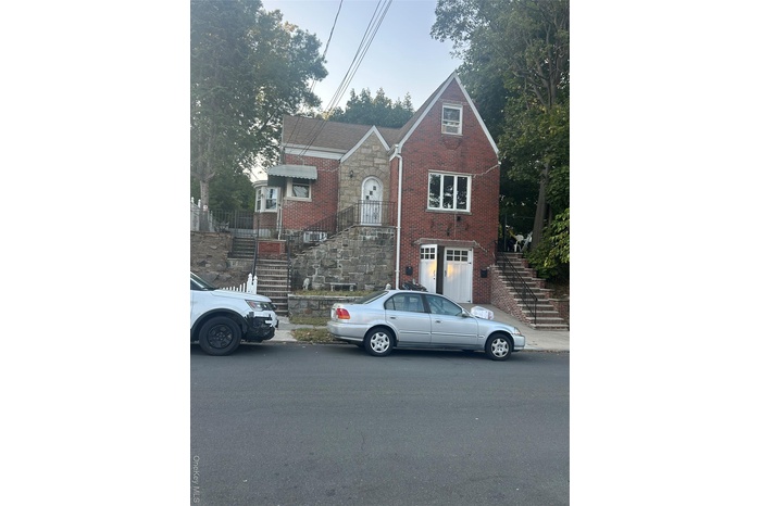 View of front of property featuring stairway and brick siding