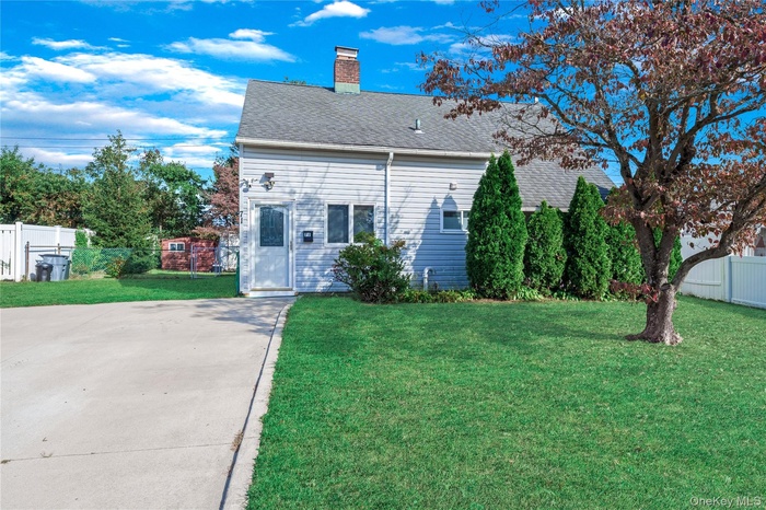 Rear view of house with roof with shingles and a chimney
