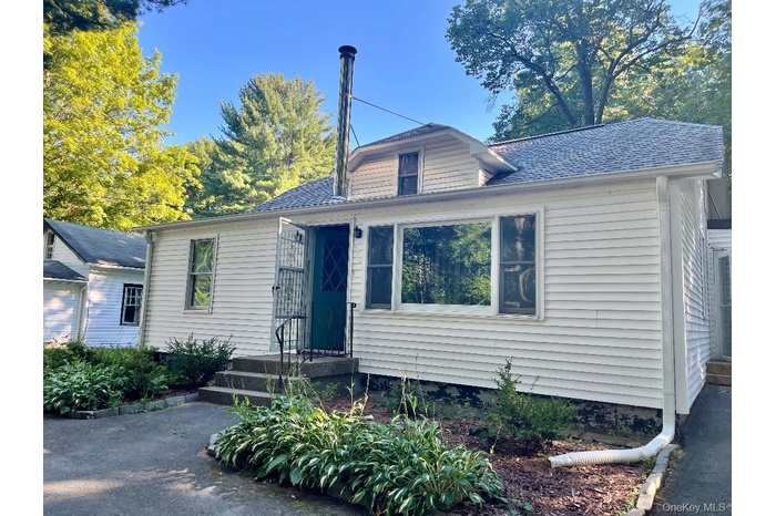 View of front facade featuring a shingled roof