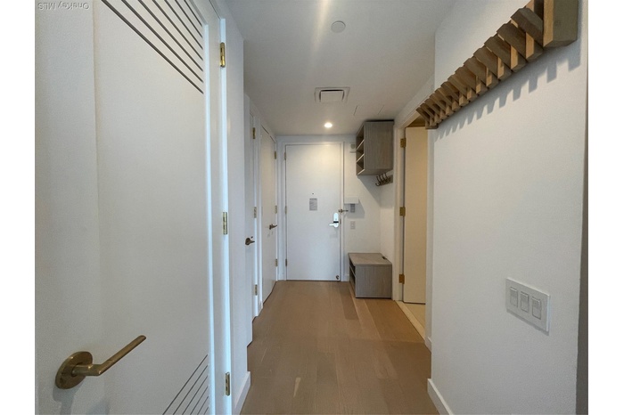 Hall with wood finished floors and recessed lighting