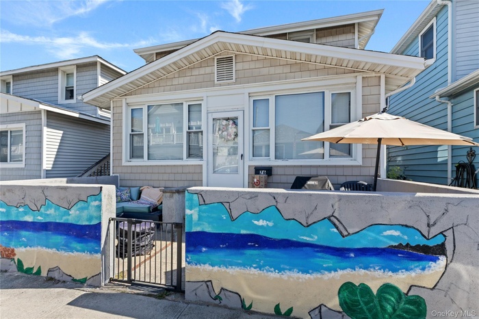 View of front of home featuring a patio and a gate