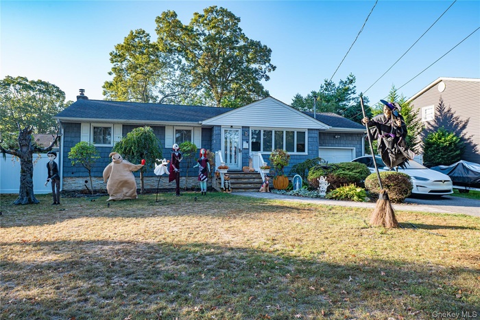 Ranch-style home featuring a front lawn, an attached garage, and a chimney