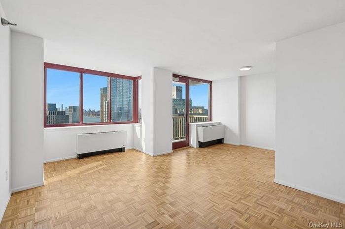 Empty room featuring radiator and a skyline view