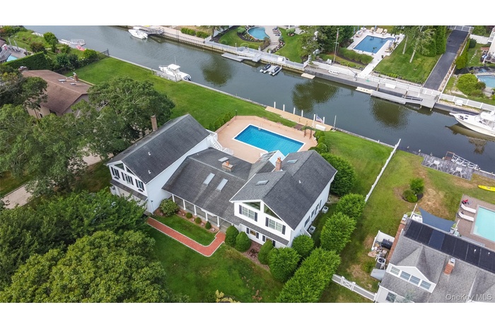 Drone / aerial view of a pool area and a large body of water