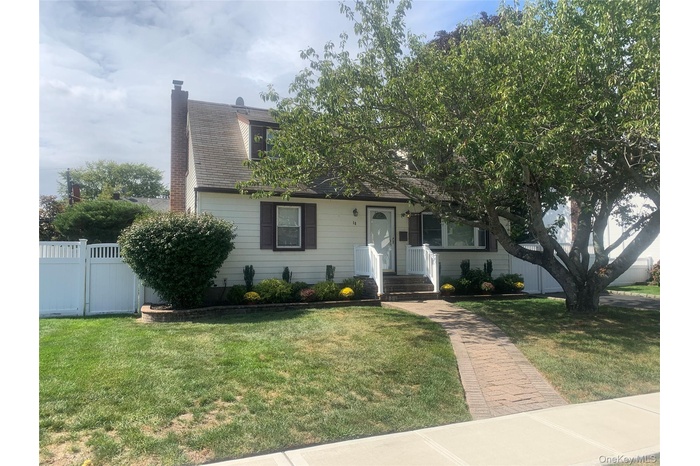 View of front of property featuring a chimney, a gate, and a shingled roof