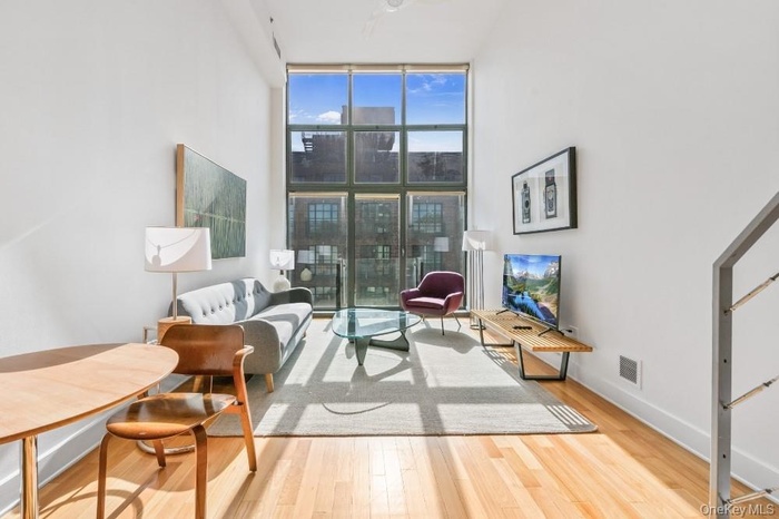 Living room with floor to ceiling windows and light wood finished floors