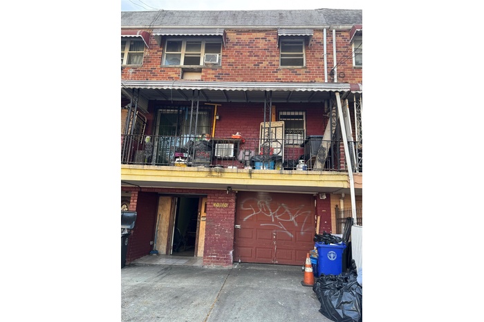 Traditional home featuring a balcony, brick siding, a garage, and driveway