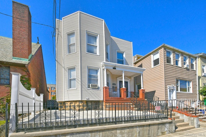 Contemporary home featuring a fenced front yard and covered porch