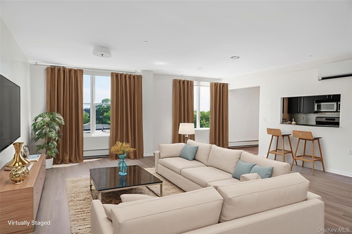 Living area with plenty of natural light, light wood-type flooring, a wall unit AC, and recessed lighting