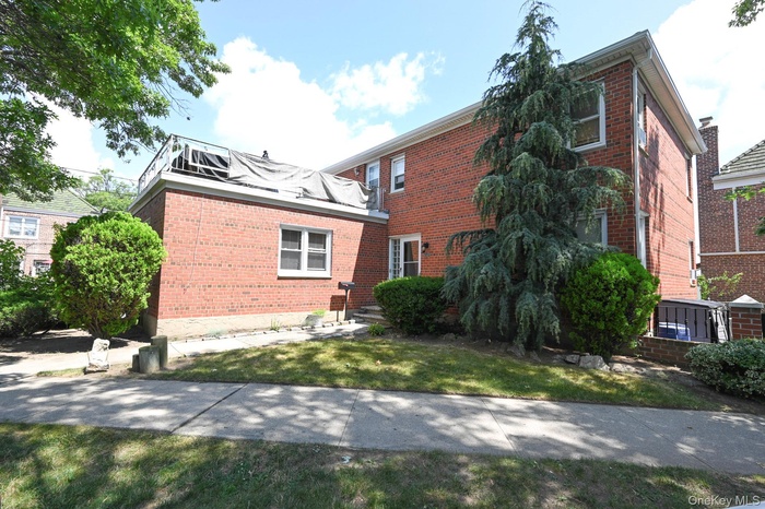View of side of home with brick siding and a yard