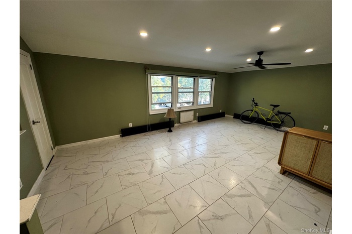 Unfurnished living room with light marble finish flooring, recessed lighting, and ceiling fan