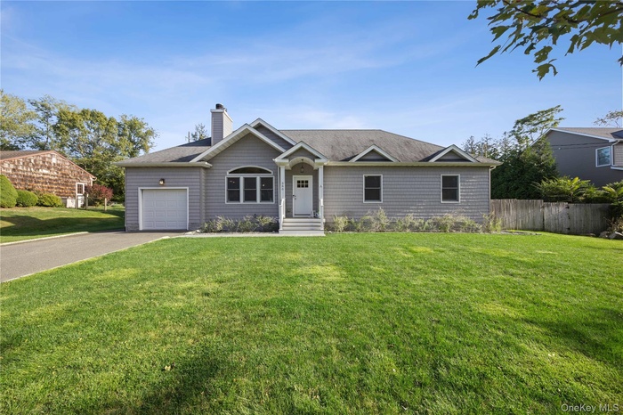Single story home featuring concrete driveway, a chimney, a shingled roof, and a garage