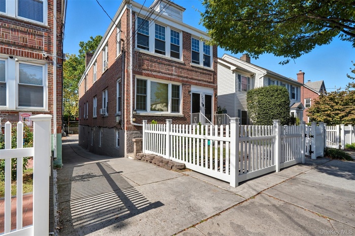 View of front of property featuring brick siding and a fenced front yard