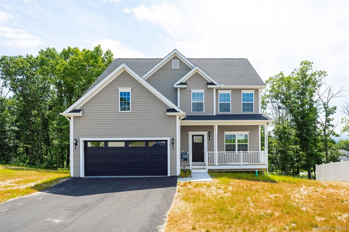 View of front of house featuring asphalt driveway, covered porch, an attached garage, roof with shingles, and a front yard