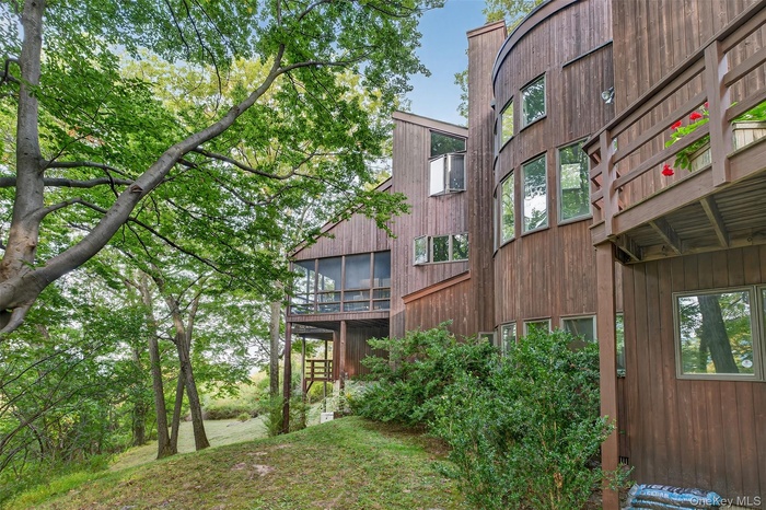 View of the back of the home. The screened-in porch is located off the kitchen and the balcony is located off the Primary Bedroom.
