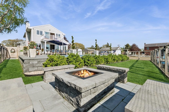 Patio / terrace with an outdoor fire pit, a patio area, a fenced backyard, a residential view, and a gate