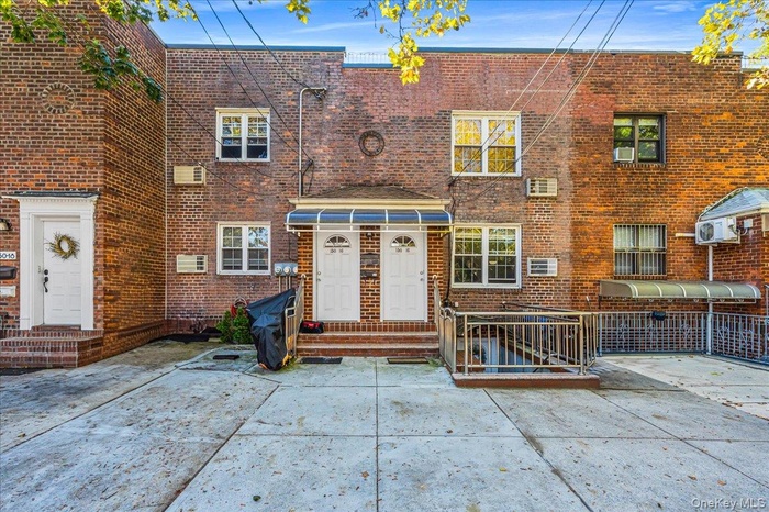 View of front of property with entry steps, brick siding, and a patio area