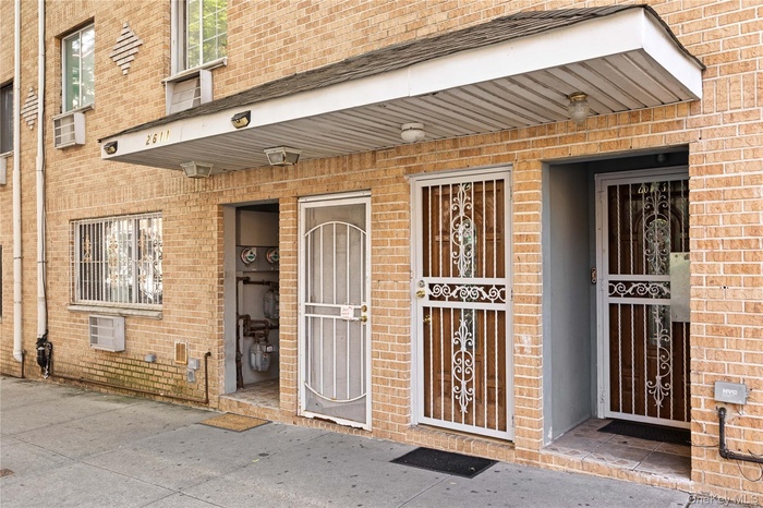 Doorway to property with brick siding and a porch