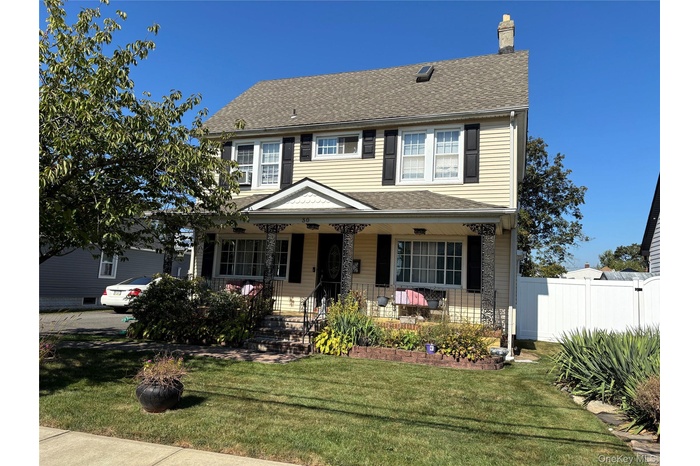 View of front of home with covered porch, roof with shingles, and a chimney