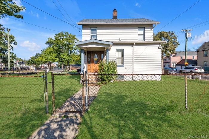 View of front of property with a gate, a chimney, and a fenced front yard