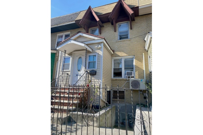 View of front facade with brick siding and a shingled roof