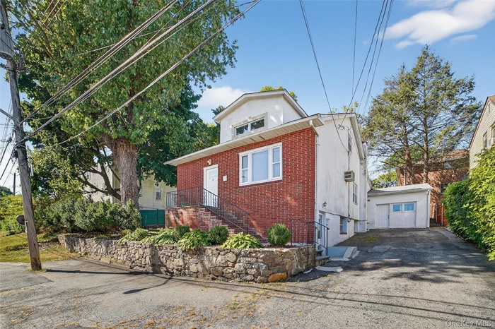 View of front of property with brick siding and asphalt driveway