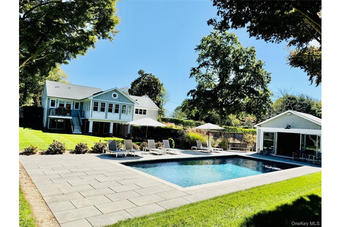 View of swimming pool with a patio area, stairs, an outbuilding, and an exterior structure