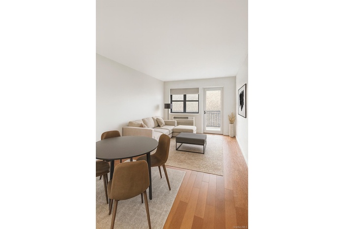Living area featuring light wood-style flooring and a wall mounted AC