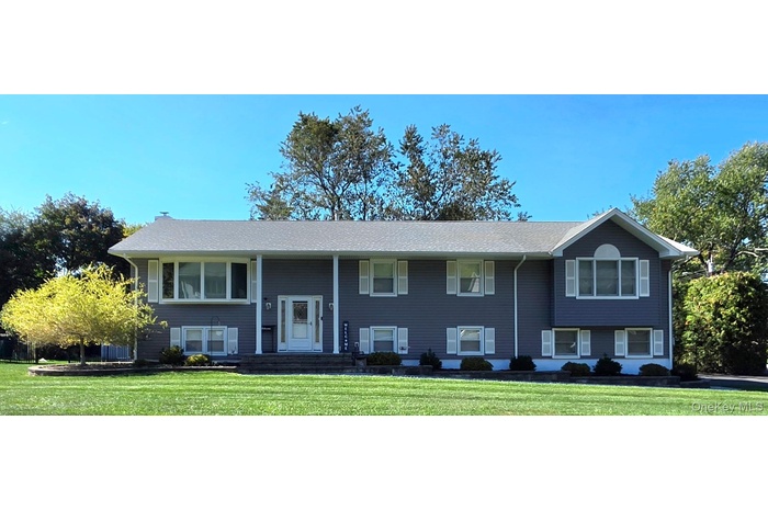 Expanded raised ranch with a front lawn