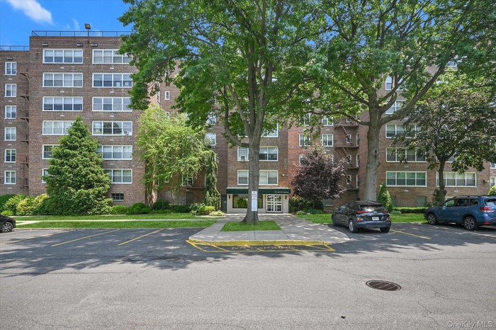 View of apartment building / complex with uncovered parking