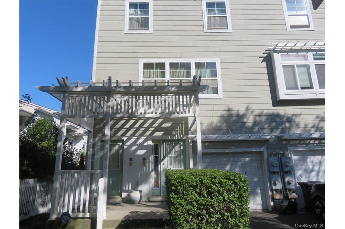 Back of property featuring a pergola and an attached garage