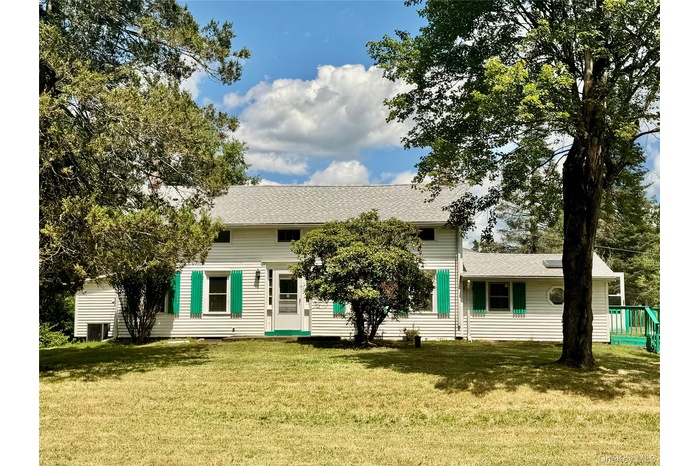 Front view of house with roof with shingles and a lawn